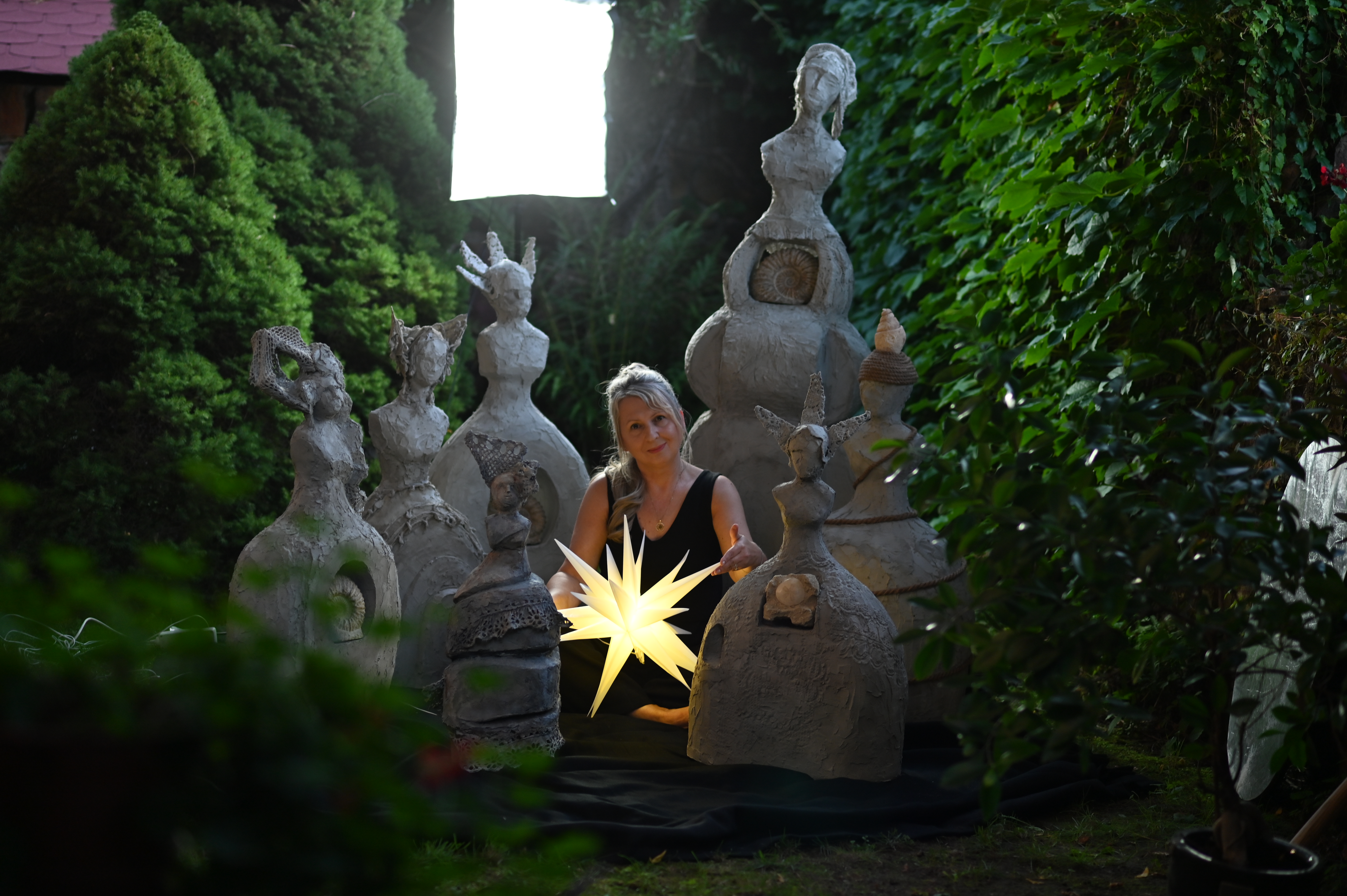 Oksana Mira kulczycka pozująca przy rzeźbach.